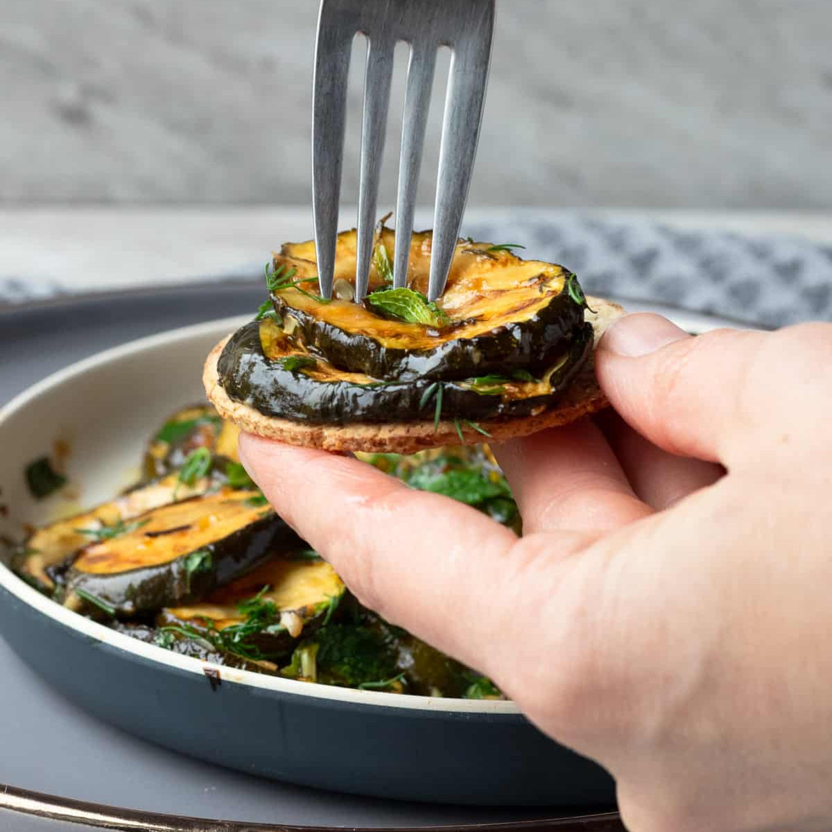 Calabacita a la parrilla marinada con hierbas mediterráneas servida en plato - La Despensería
