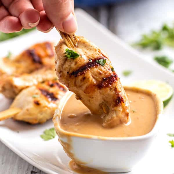 Brochetas de pollo satay tailandesas con salsa de cacahuate servidas en plato - La Despensería
