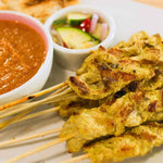 Brochetas de pollo satay tailandesas con salsa de cacahuate servidas en plato - La Despensería
